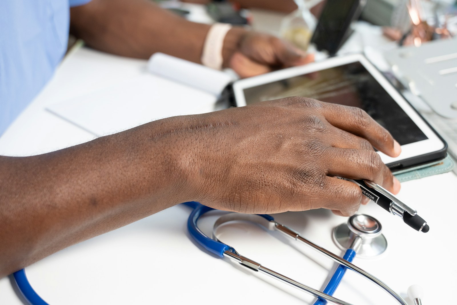 Healthcare professional reviewing digital chargemaster records with a tablet and stethoscope